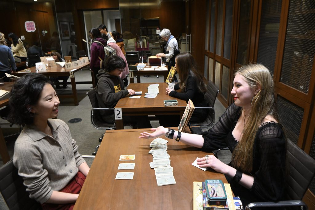 Student in the Special Collections Reading Room receiving advice from tarot cards.