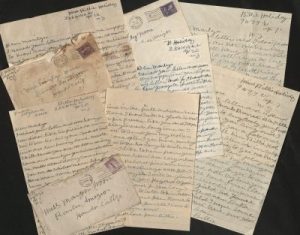 Handwritten letters by Billie Holiday, arrayed in an overlapping pile against a black background.