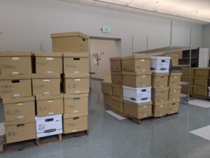 stacked boxes of archival papers in a warehouse setting