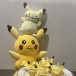 Cupcakes decorated to look like Pikachu with stuffed Pikachus behind them